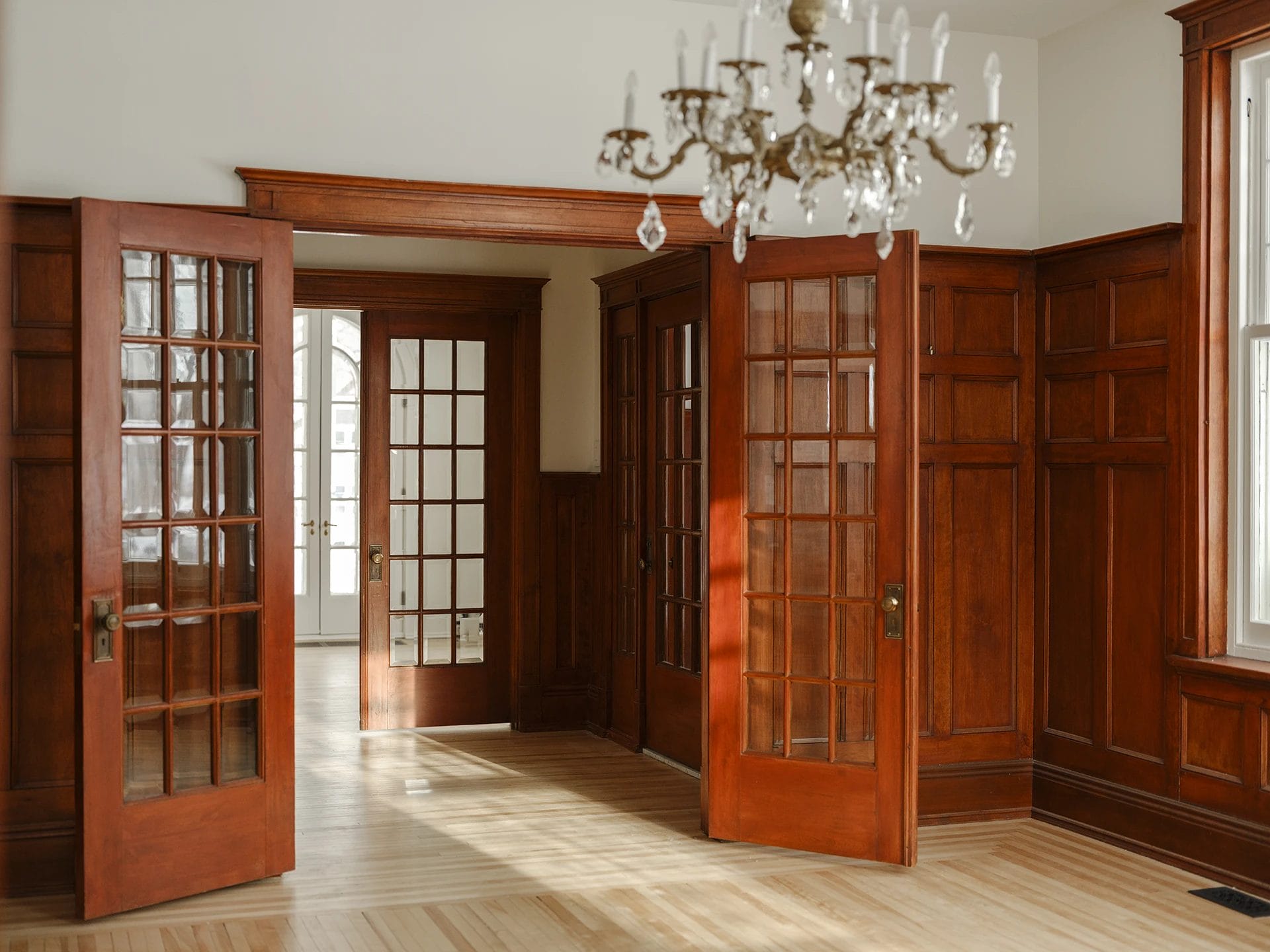 Restauration maison centenaire – boiseries et portes françaises en bois massif, mises en valeur dans un intérieur lumineux.